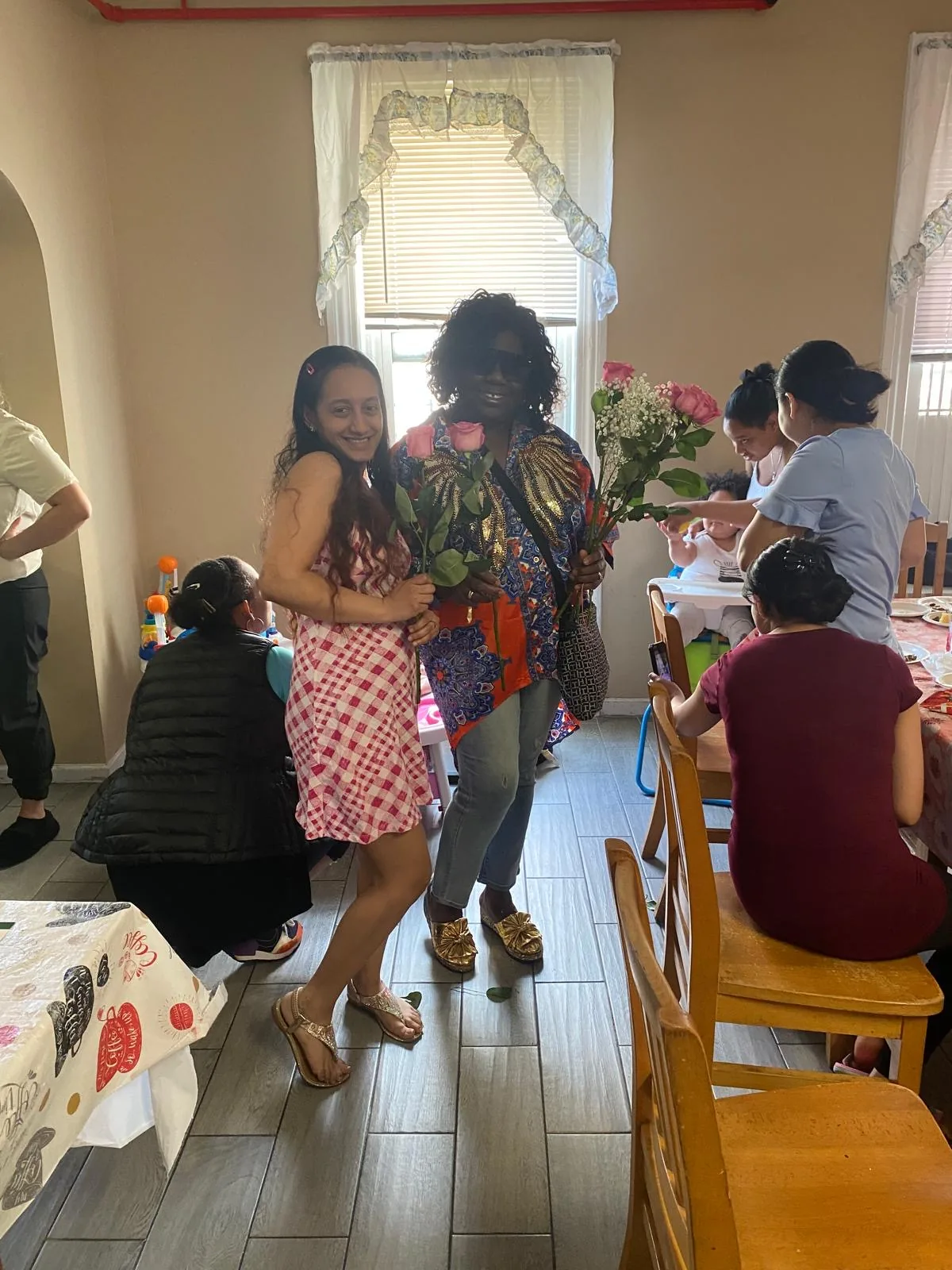 A CGMOH volunteer presents a rose and gift to a Mother's Day guest