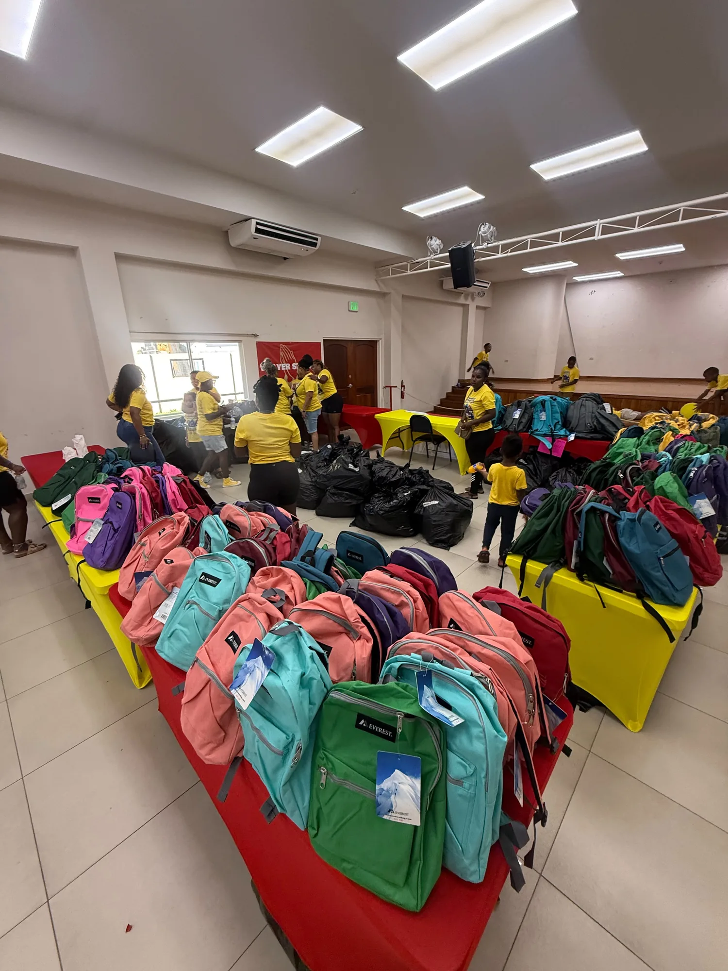 Colorful backpacks arranged for the CGMOH Trinidad back-to-school outreach