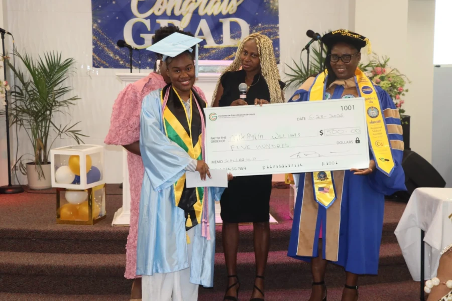 CGMOH representatives stand with a scholarship recipient holding her award check