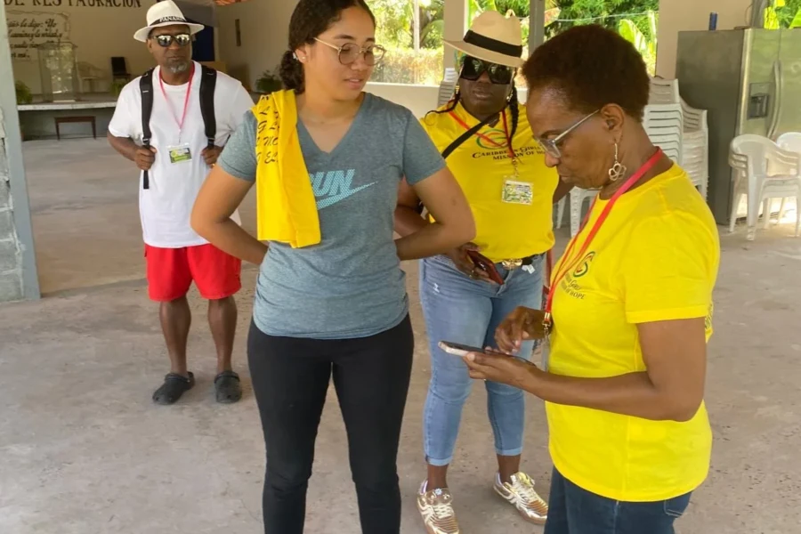 A CGMOH volunteer presents an item to a community member at the center