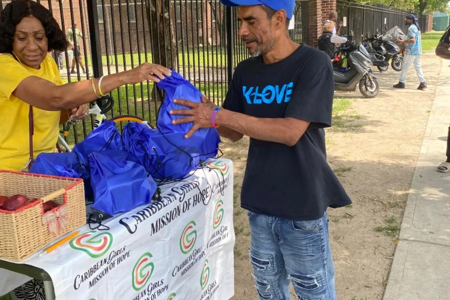 A father receives a blue gift bag from volunteers at the CGMOH table