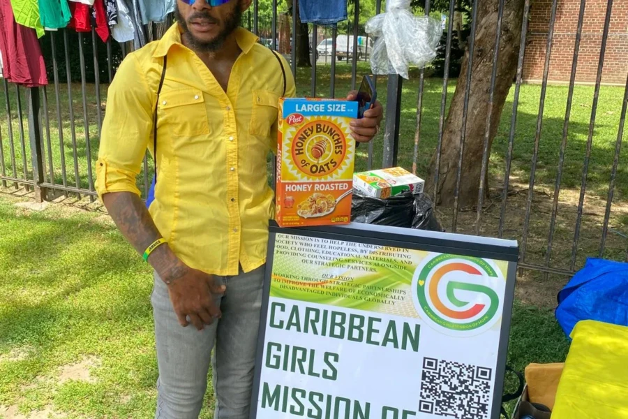 A community member displays a donated food item beside the giveaway table