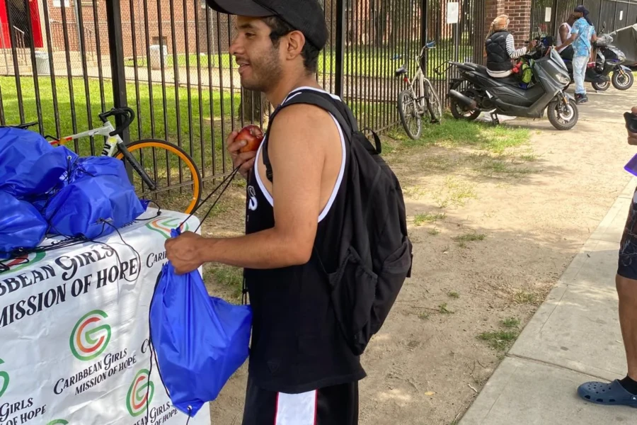 A father speaks with volunteers while receiving his Father's Day care package