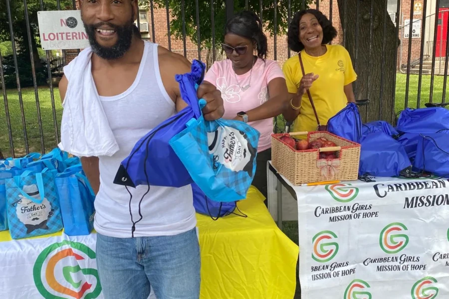 A smiling father holds his care package at the community giveaway
