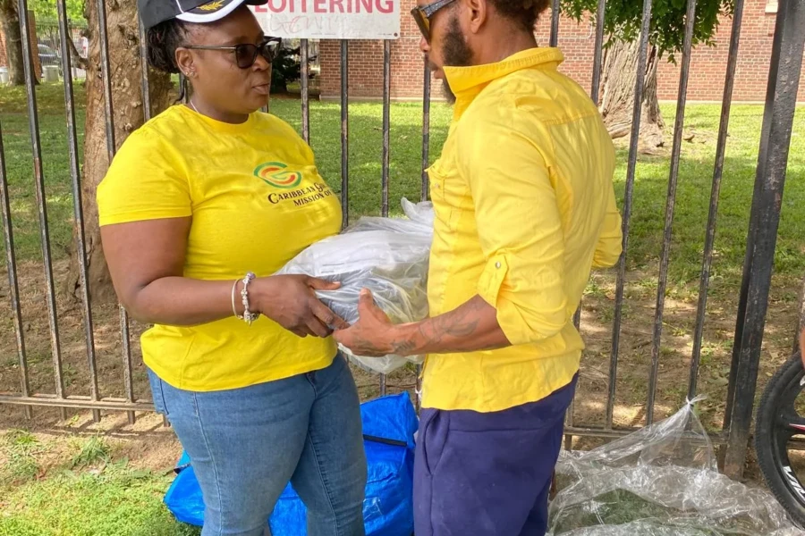 A CGMOH volunteer presents a wrapped item to a Father's Day attendee