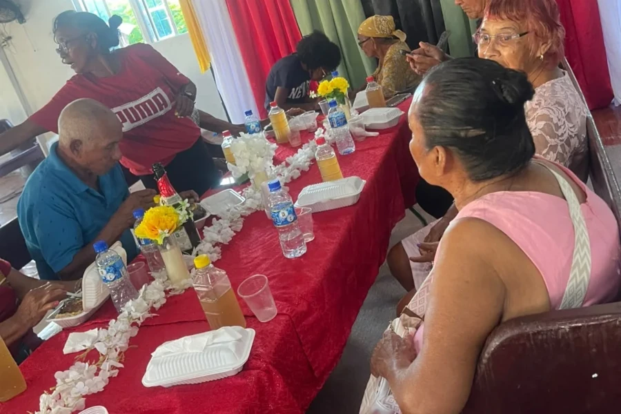 Community members share food and conversation around the outreach table