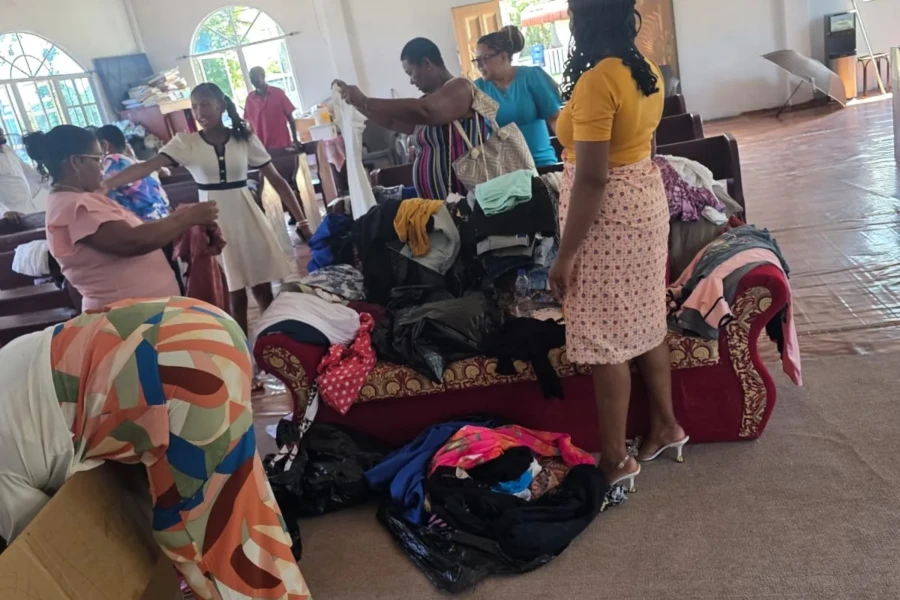 Volunteers organize donated clothing for families inside a Kawkani community space