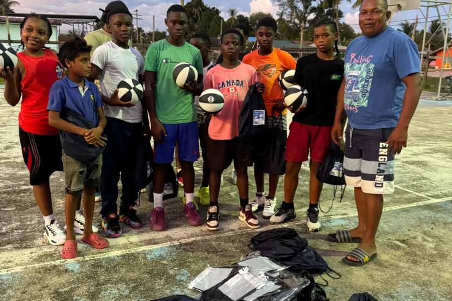 Kawkani youth pose together with donated volleyballs, clothing and sports supplies