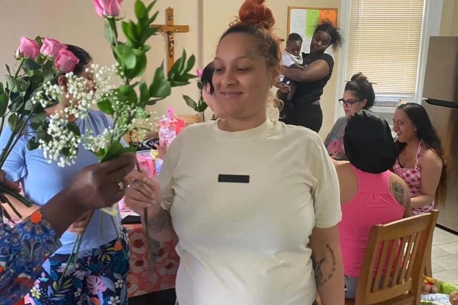 A woman receives a pink rose during the CGMOH Mother's Day celebration